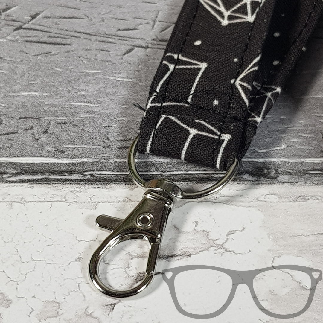 Dice Constellation Lanyard, black fabric with white dice in a constellation pattern. The lanyard features a lobster style clip for your keys or ID Card, and a quick release safety clip