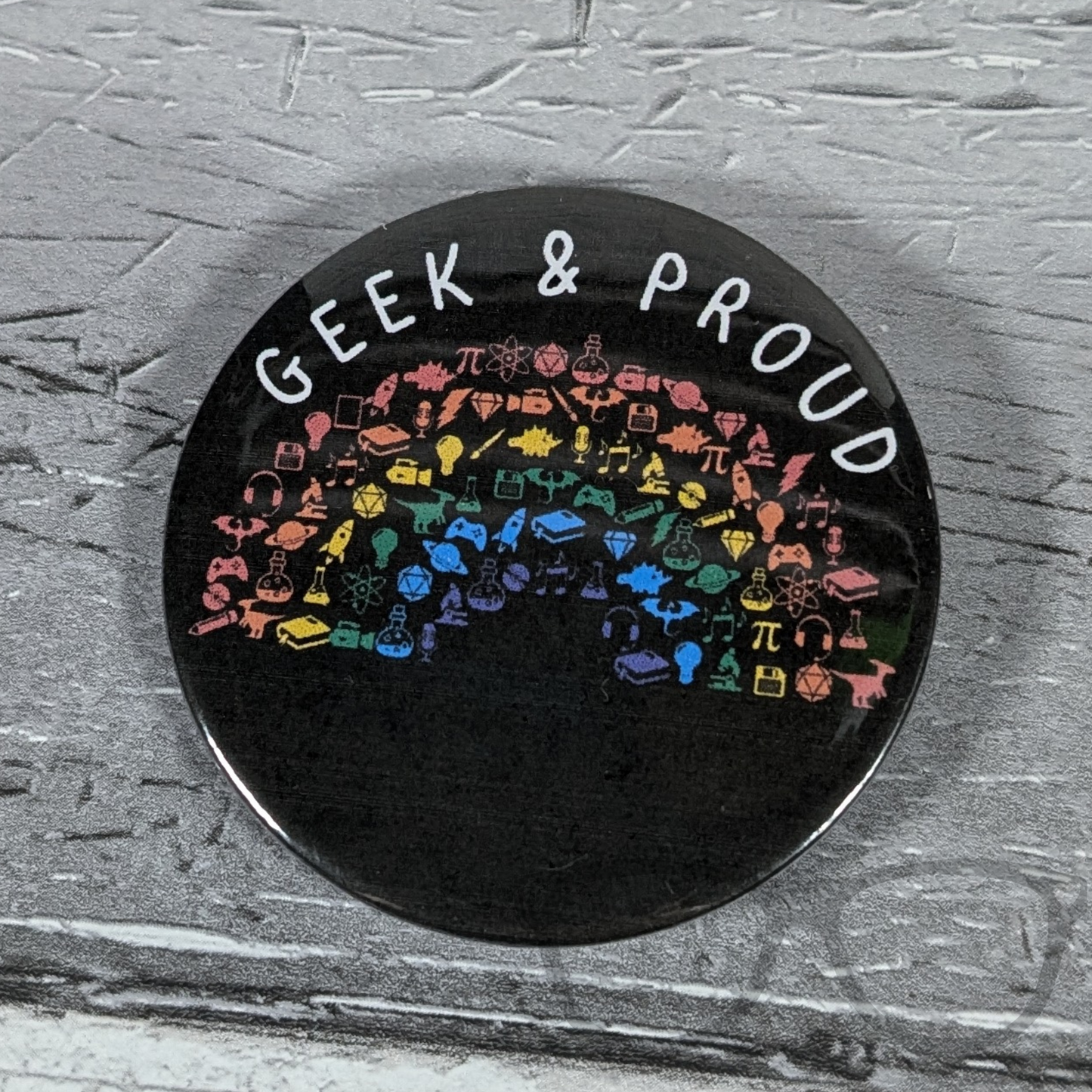 Geek and Proud 58mm badge with rainbow design, showcasing pride for science, computing, and space enthusiasts.