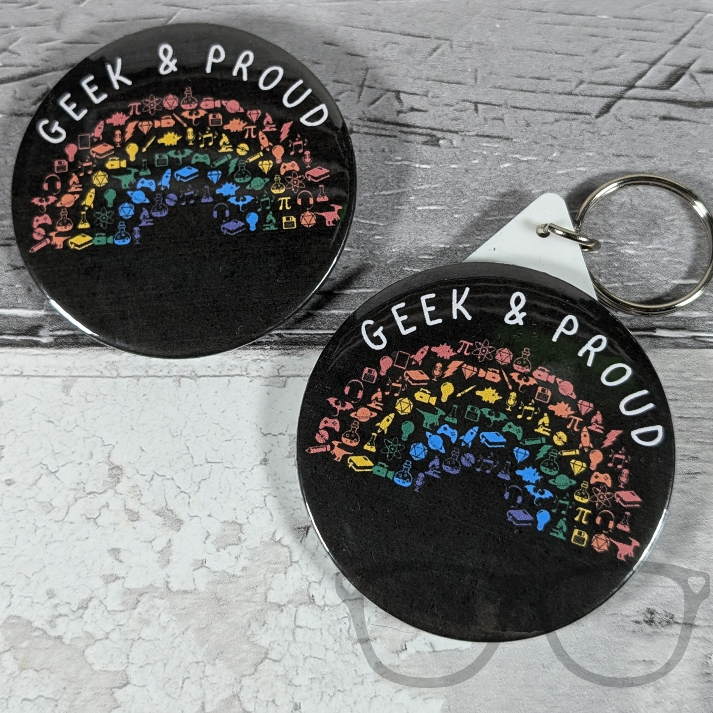 Geek and Proud 58mm badge and keyring set, featuring a vibrant rainbow design, perfect for fans of science, computing, and space.