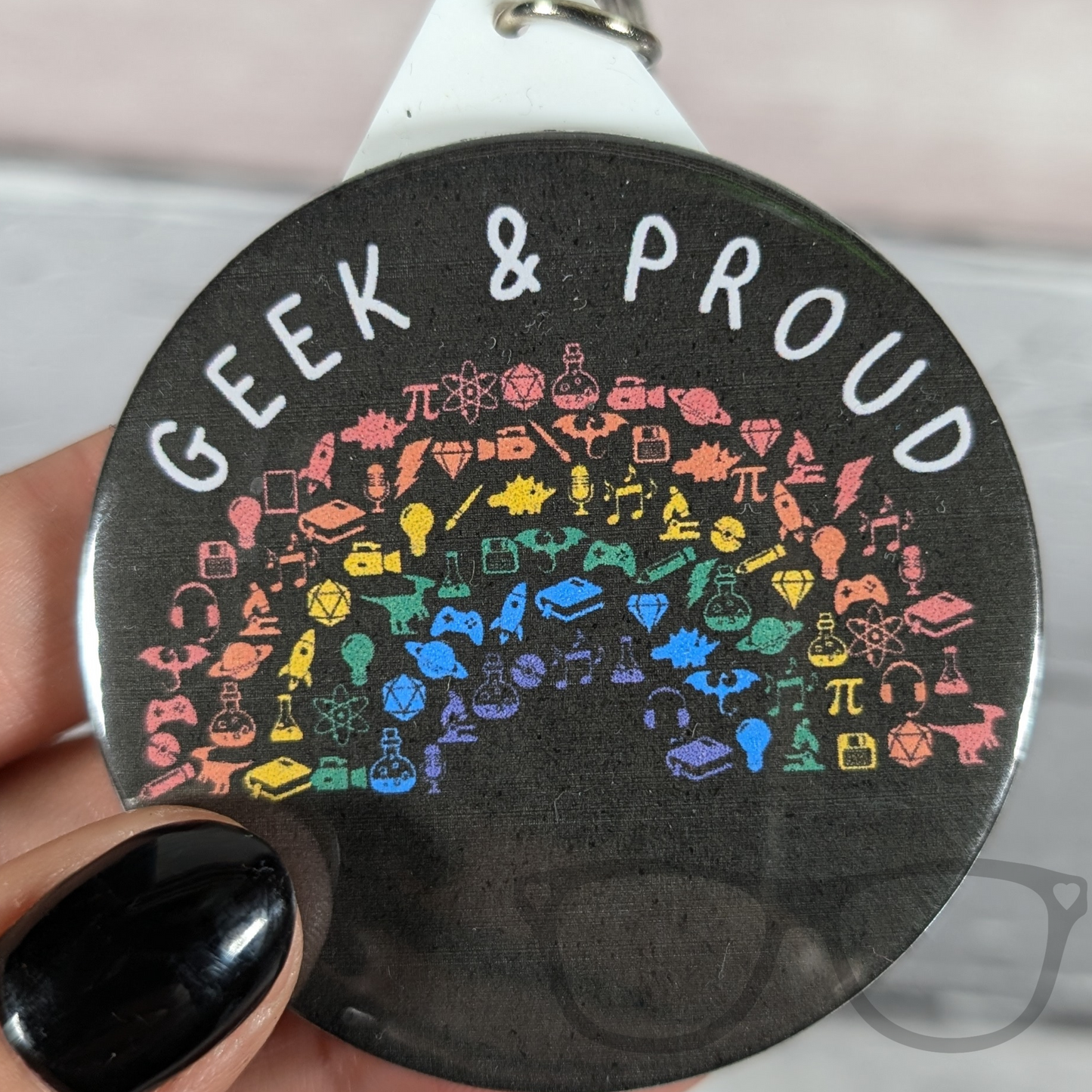 Close-up of Geek and Proud keyring featuring a rainbow design, ideal for science, computing, and space enthusiasts.