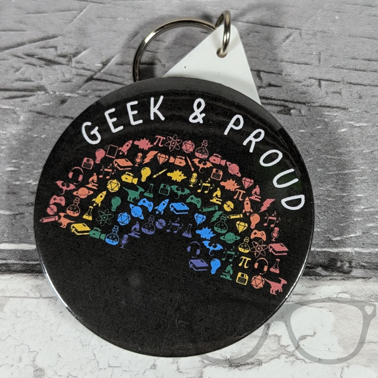 Geek and Proud 58mm keyring with a rainbow design, celebrating geek culture, science, and space exploration.