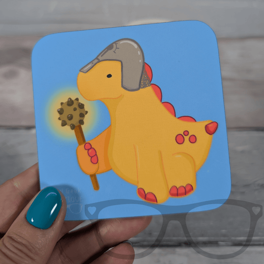 Blue square drink coaster featuring Derek the yellow stegosaurus as a cleric holding a mace, Mini Geek Boutique kids’ coaster