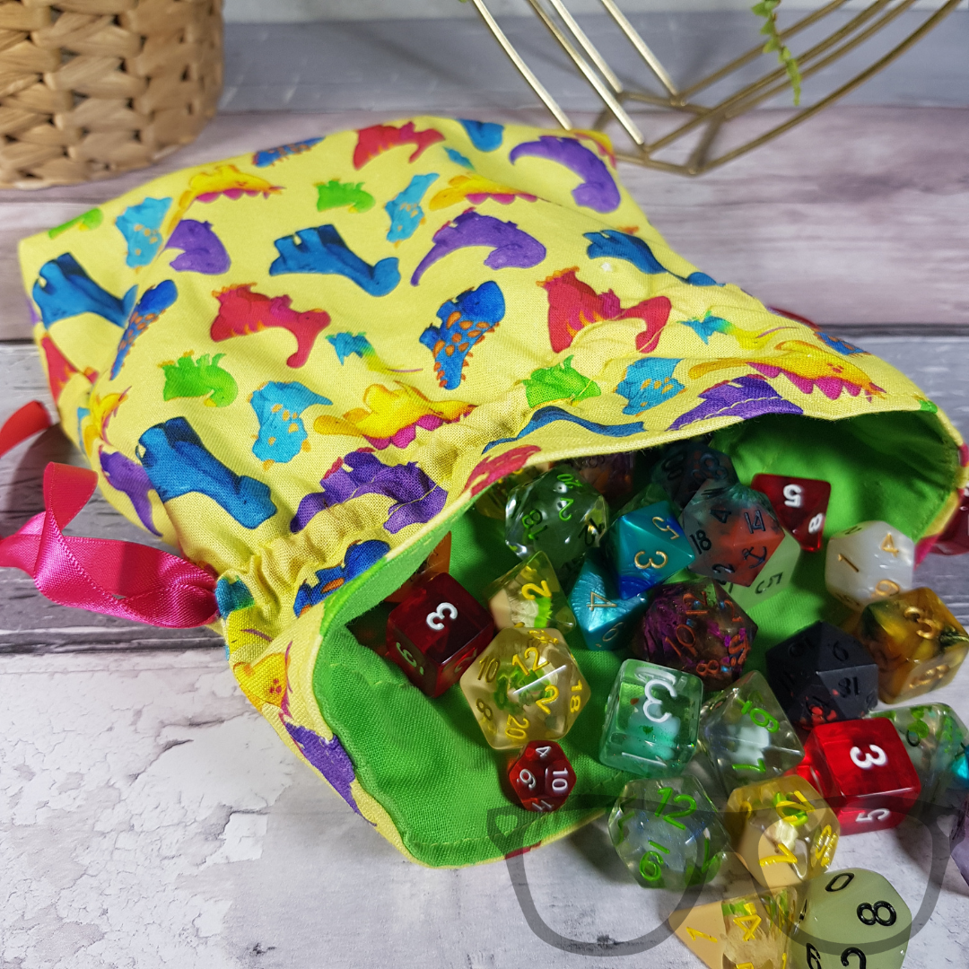 Dinosaur drawstring bag showing how much dice it can hold. Dice not included