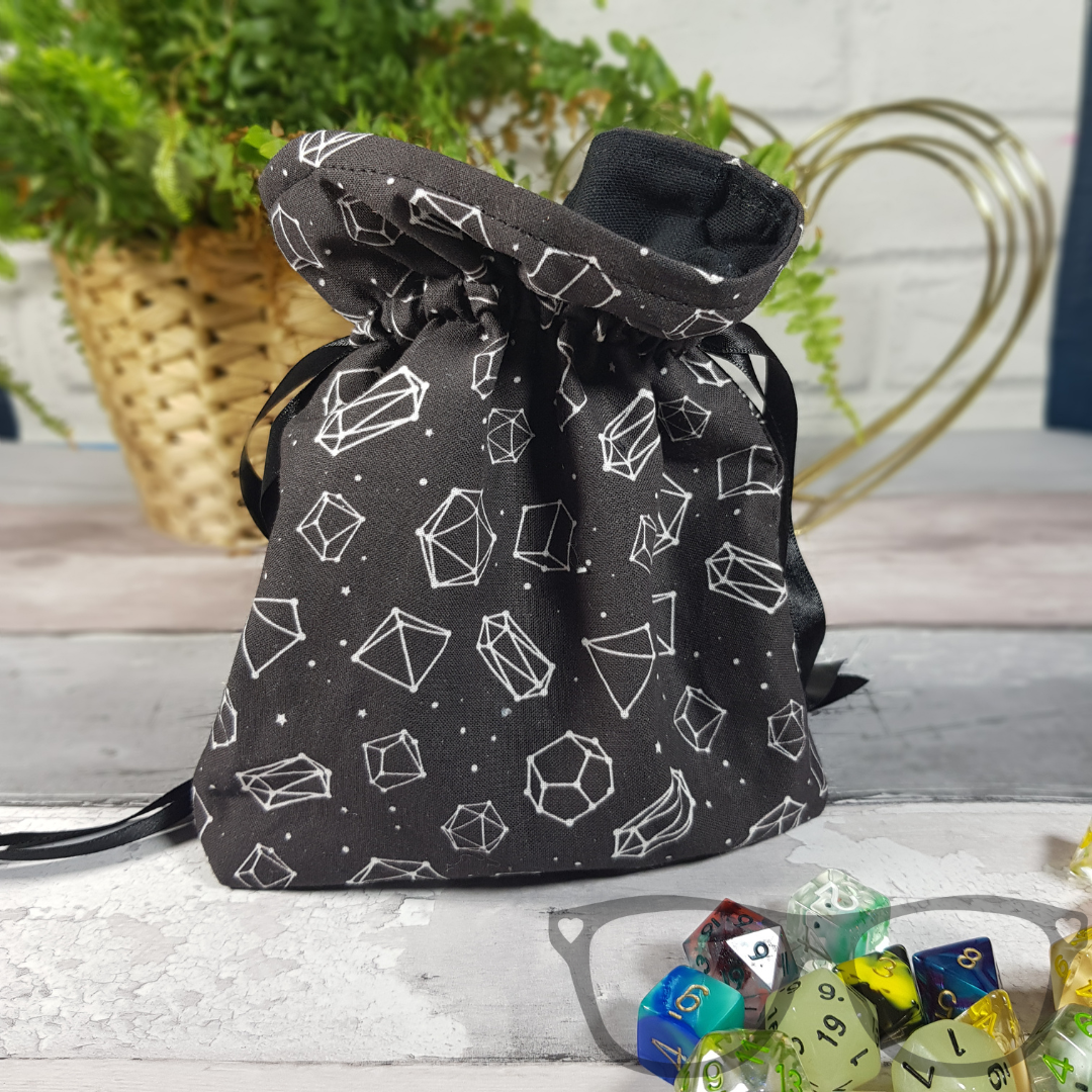 White dice constellations on a black background, lined with a black fabric and secured with a black ribbon.