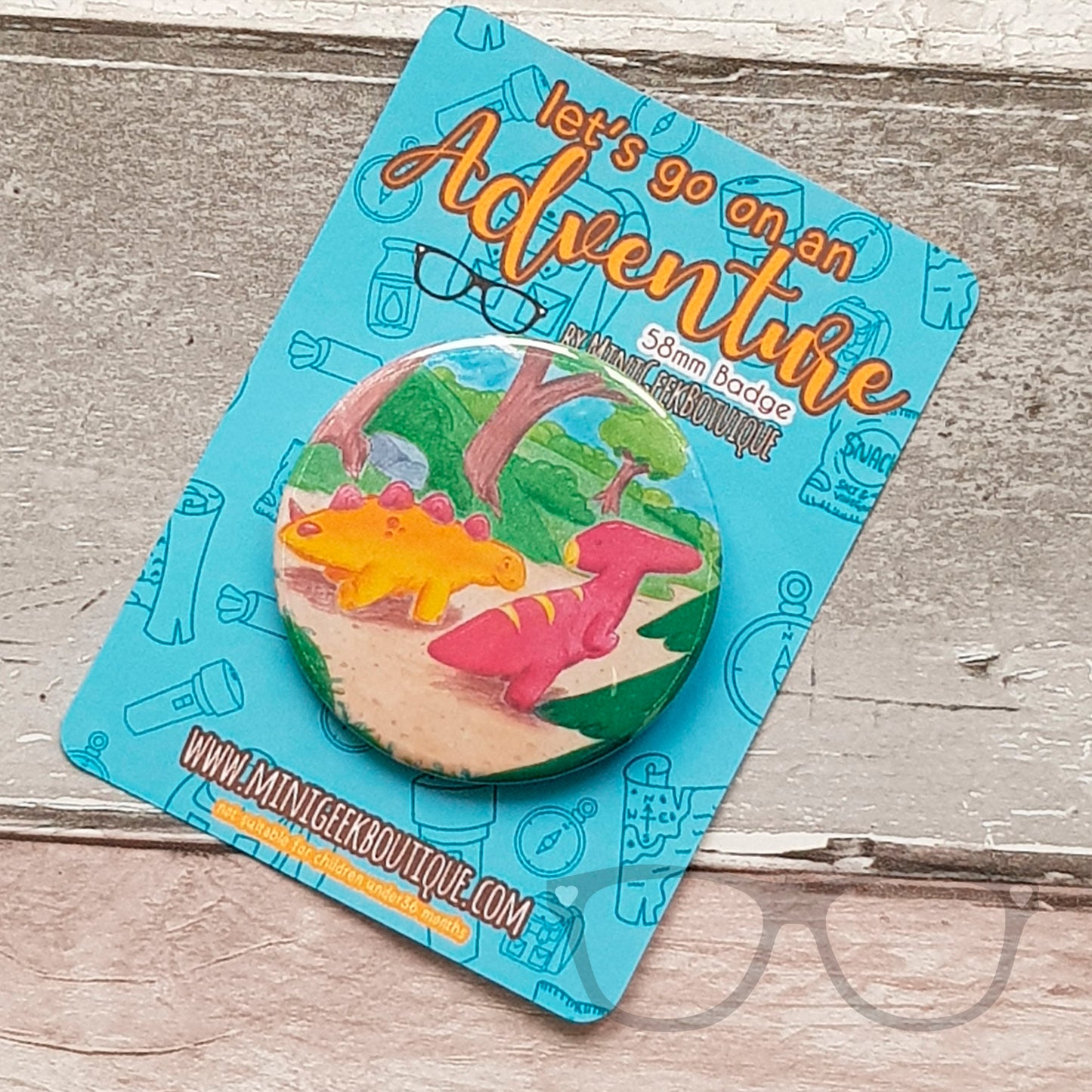 This 58mm badge shows the illustration of Derek and Irene the dinosaurs starting off on their adventure.