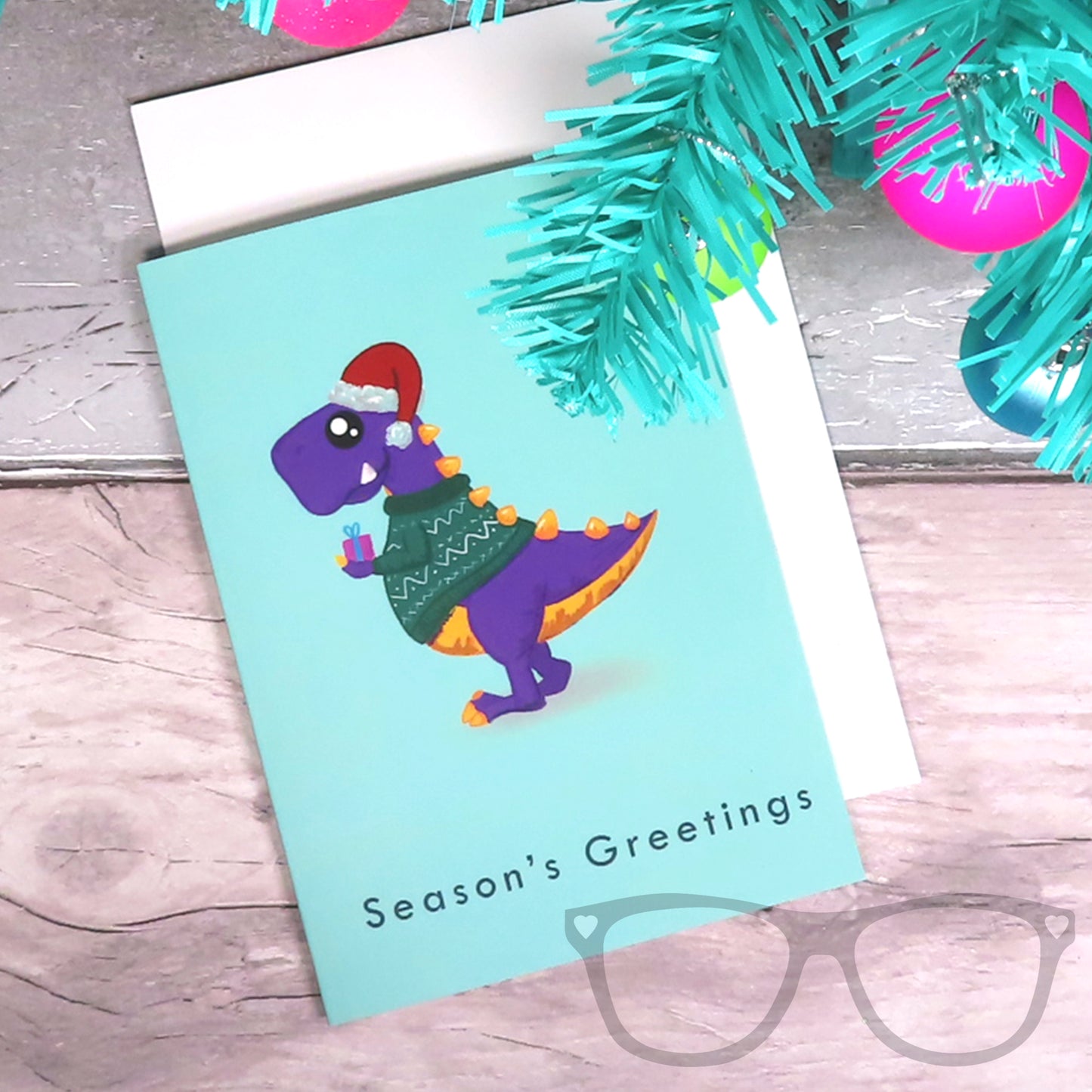 T.rex Christmas card laying flat on a white envelope