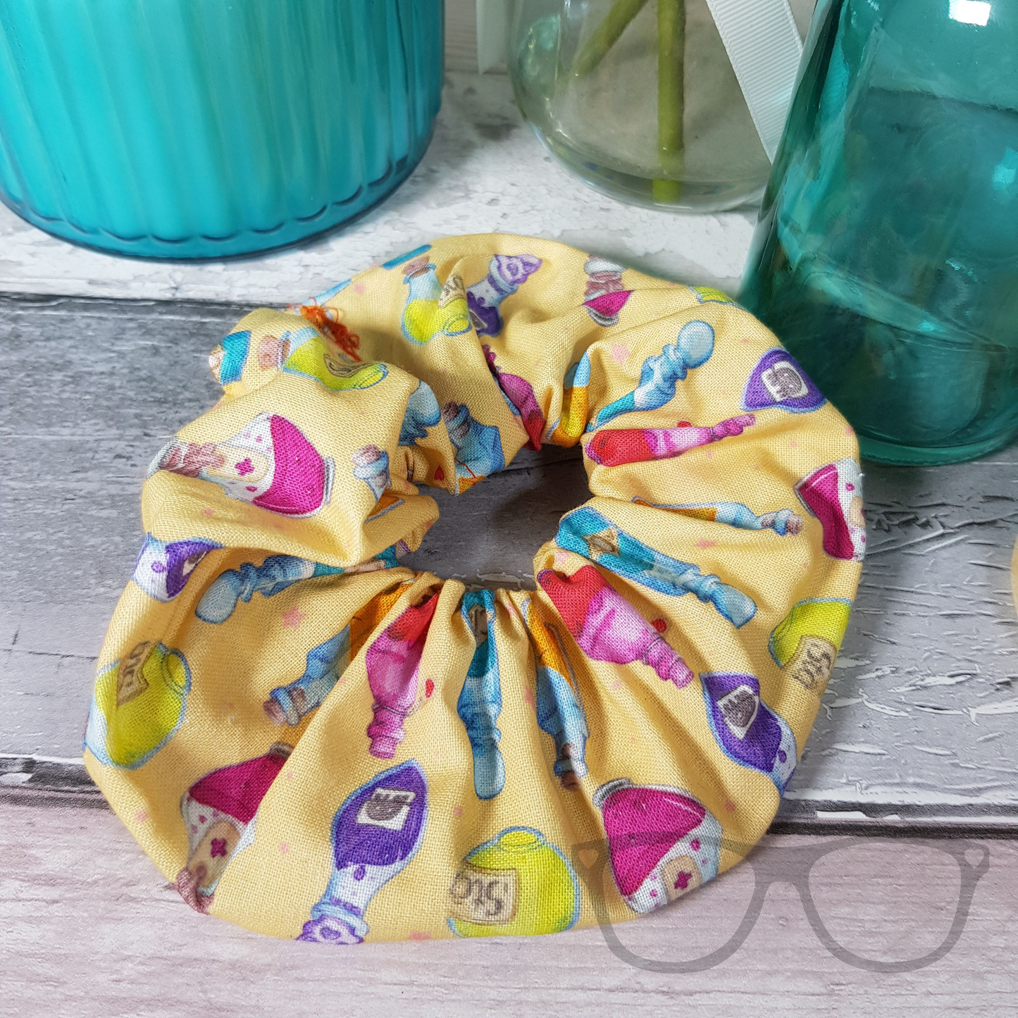 Yellow hair scrunchie with potion bottles, made in house.