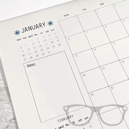 Closeup of the dinosaur calendar showing the month of January with space for notes, and a grid layout to mark out important dates 