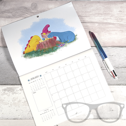 The dinosaur calendar opened showing the first month, January. The illustration shows Derek, Irene and Brenda the dinosaurs playing a tabletop roleplaying game.