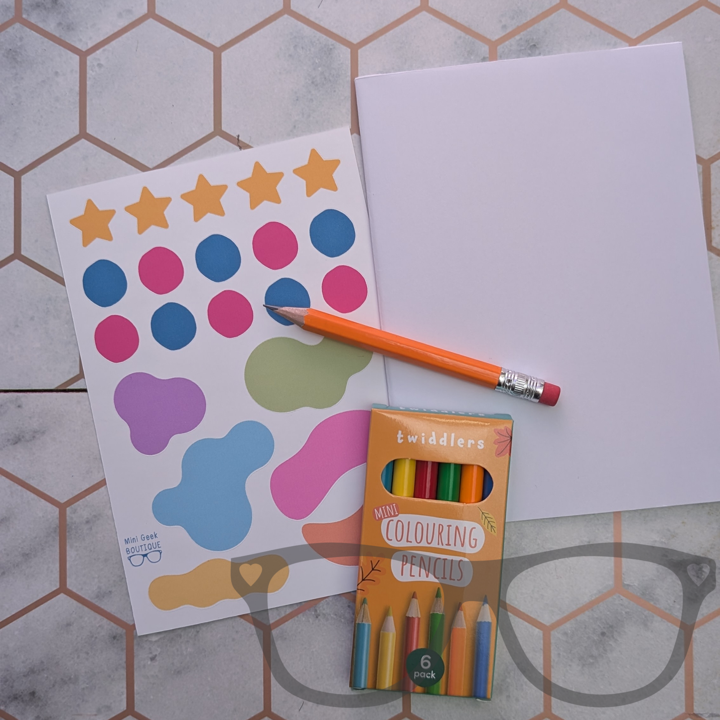 DIY Zine kit contents, blank folded zine, coloured pencil, sticker sheet, drawing pencil with eraser.