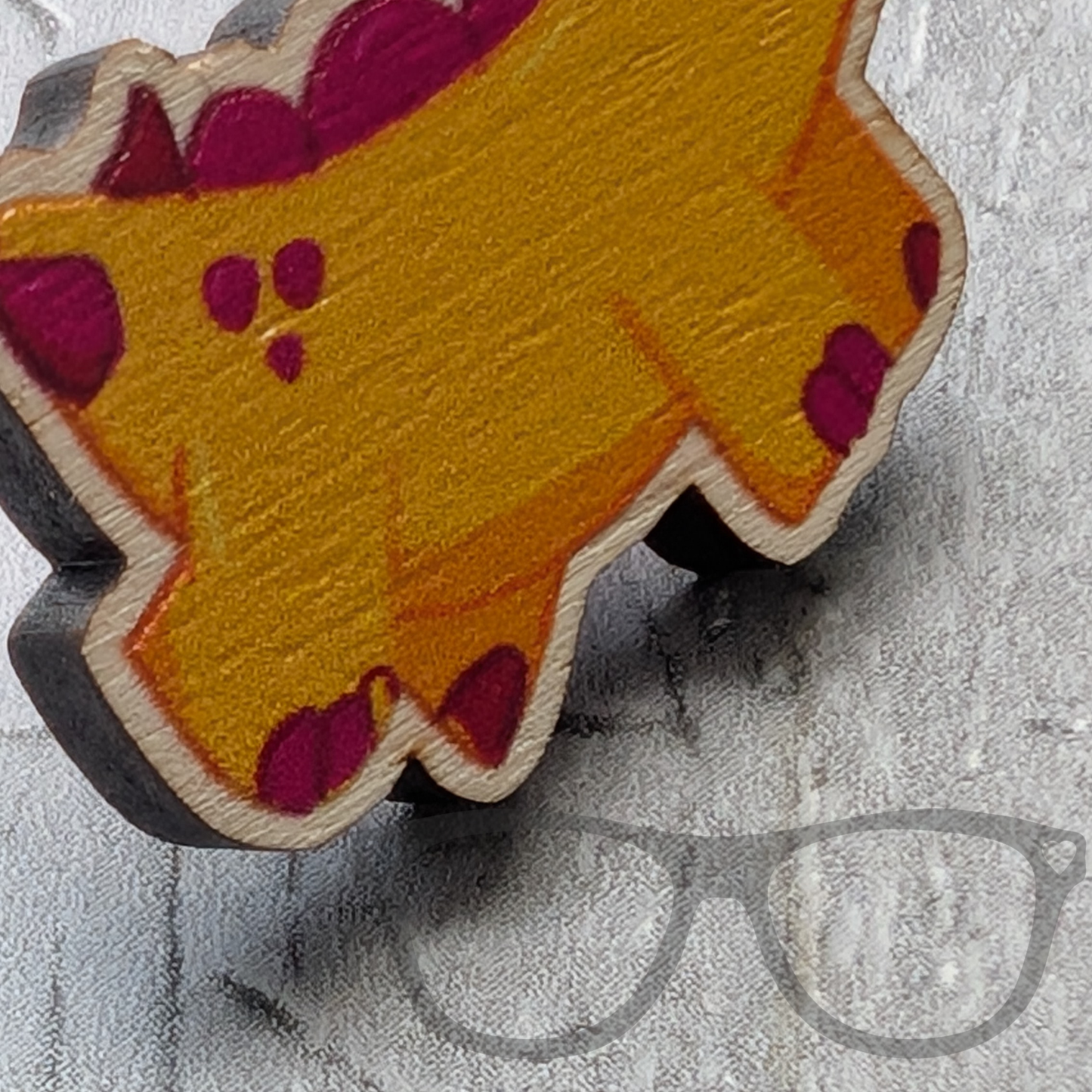 close up of Derek the stegosaurus wooden pin