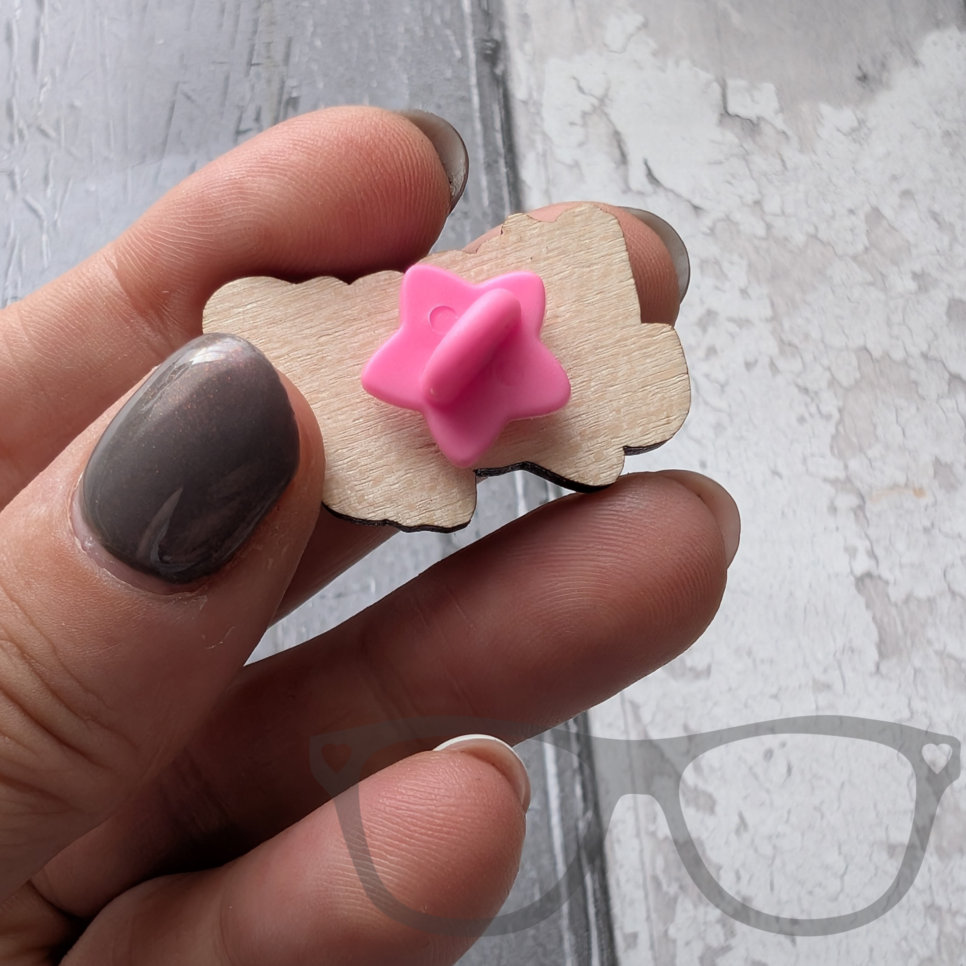 The back of the derek the stegosaurus wooden pin showing the pink star fastening
