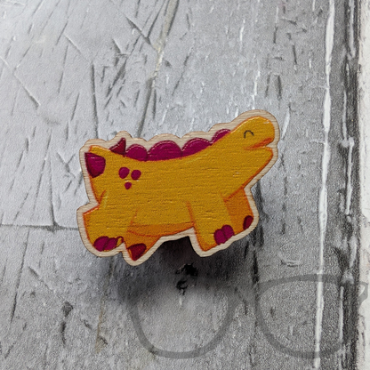 Wooden pin showing a full colour design of Derek the yellow stegosaurus