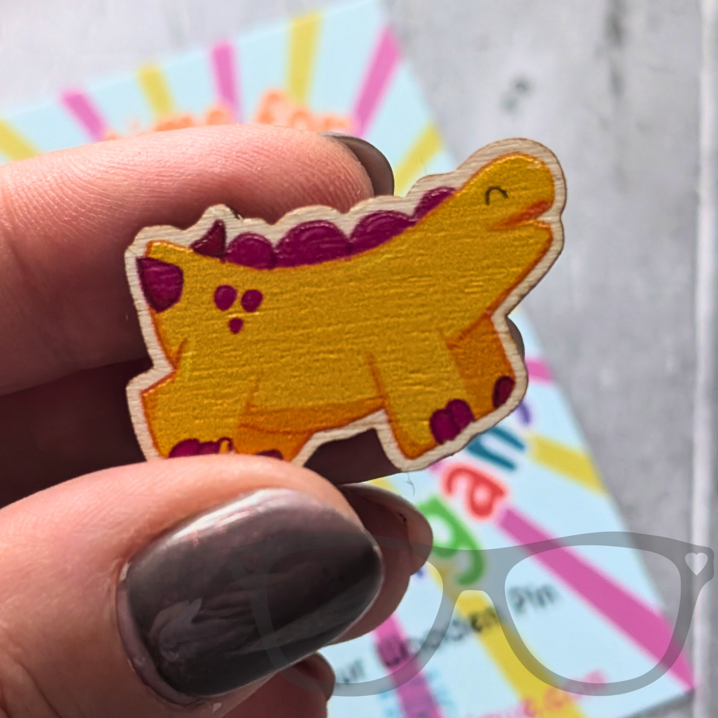 Dinosaur wooden pin showing Derek the stegosaurus