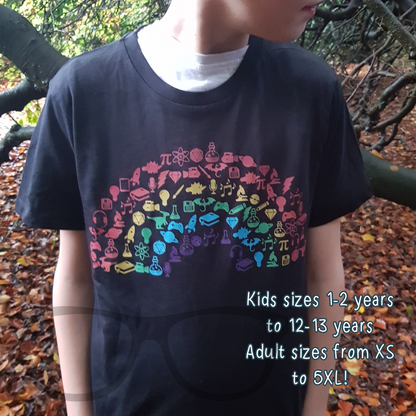 black t-shirt with a rainbow showing icons associated with being a geek. The text reads "kids sizes 1-2 years to 12-13 years Adult sizes from XS to 5XL!"