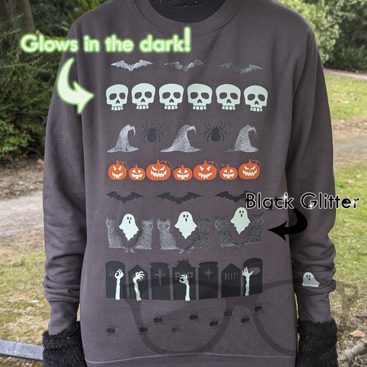 Grey Halloween sweater in the style of an ugly sweater, with text that reads "Glows in the dark" and "black glitter" which highlights all the fun graphics on the sweater
