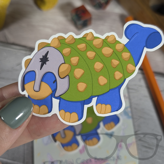 Hank the Tank Paladin Ankylosaurus vinyl sticker being held, featuring a Dungeons and Dragons inspired dinosaur design