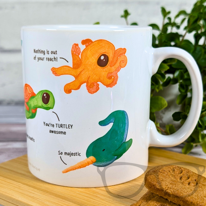 Motivational Marine life mug showing an orange octopus saying "Nothing is out of your reach" and a Narwhal saying "So majestic"