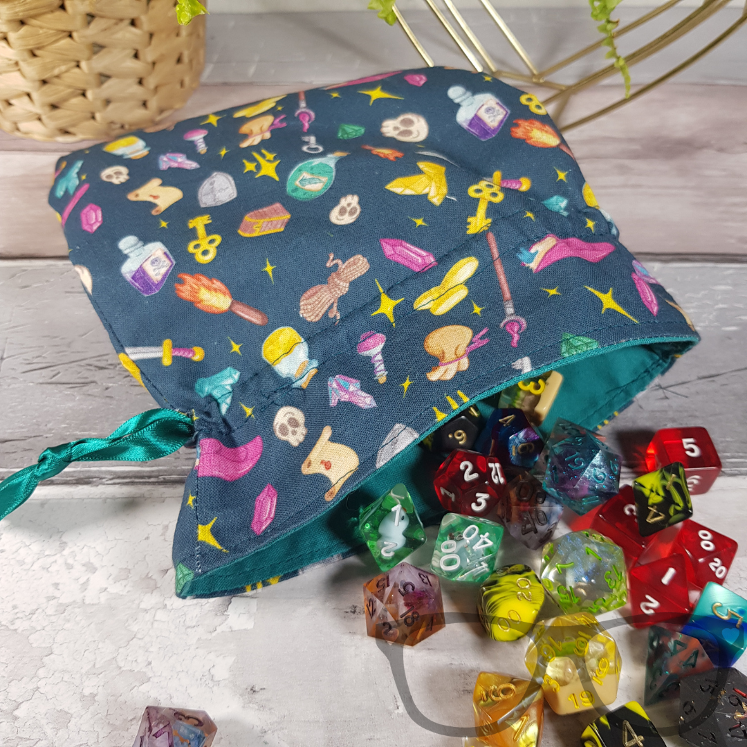 Teal Drawstring bag ideal for carrying dice, minis, snacks and little trinkets. Teal fabric with icons of fantasy genre, lined with a go-ordinating green fabric and secured using a green ribbon. Dice not included