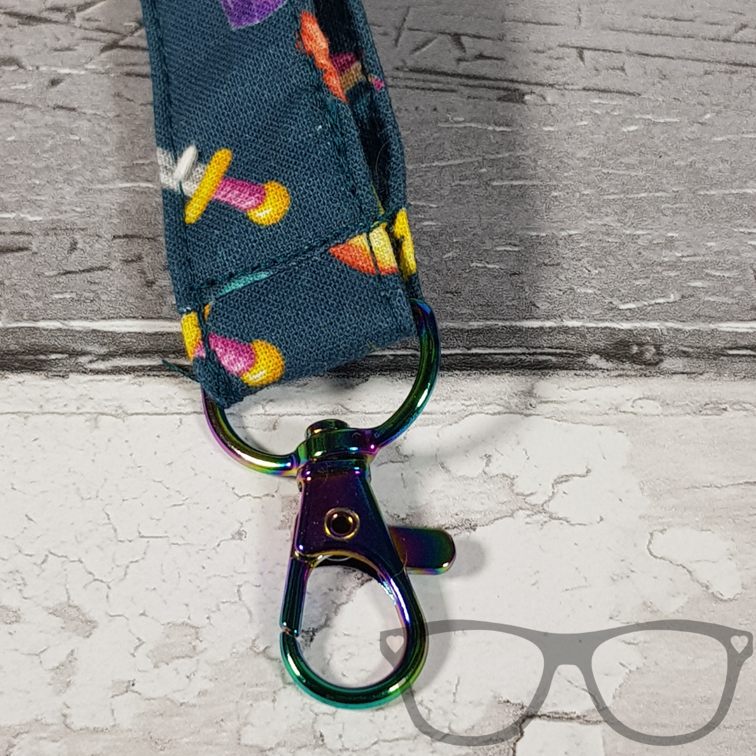 Teal Fantasy RPG Lanyard, teal fabric with colourful fun fantasy iconography in a pattern. The lanyard features a lobster style clip for your keys or ID Card, and a quick release safety clip