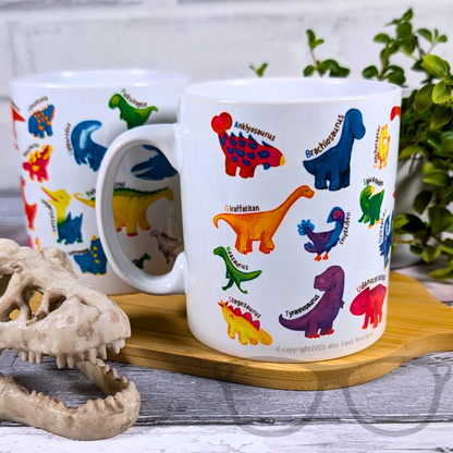 A to Z Dinosaur mug showing all of the mug illustrations on a wooden board, a plant in the back ground and a dino skull in the foreground