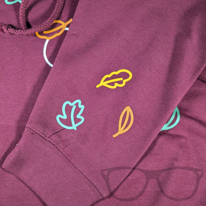 Sleeve detail showing autumn leaves on a burgundy hoodie
