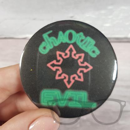 Black 58mm badge with green neon light style text that reads " Chaotic Evil" the text goes around a red chaotic arrow symbol