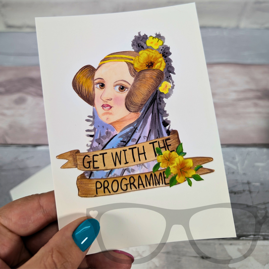 A fun and empowering postcard featuring Ada Lovelace, illustrated with a confident expression and a banner that reads "Get with the programme" — a nod to her trailblazing work in computing.