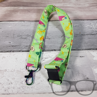 Green Fantasy RPG Lanyard, Light green fabric with colourful fun fantasy icons in a pattern. The lanyard features a lobster style clip for your keys or ID Card, and a quick release safety clip
