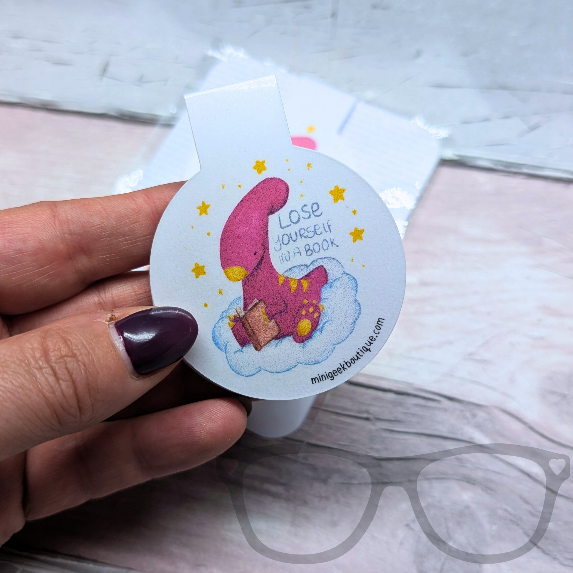 Magnetic bookmark with Irene the Parasaurolophus on a cloud and the text "Lose yourself in a book." A perfect reading accessory for avid readers and dinosaur fans.