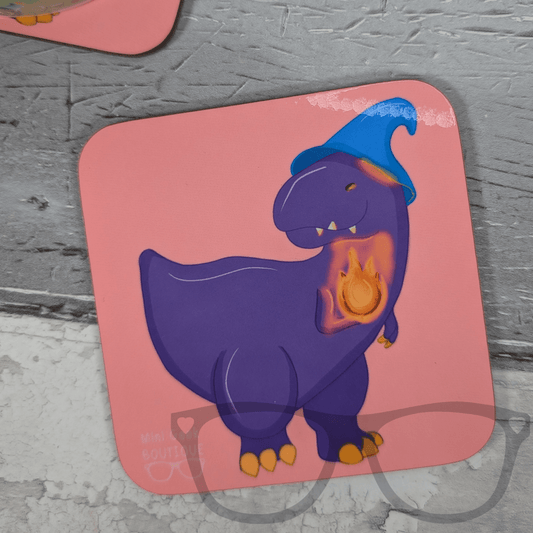 Pink square drink coaster featuring Mr Bolan the purple T. Rex wizard wearing a blue hat and holding a magical flame, Mini Geek Boutique