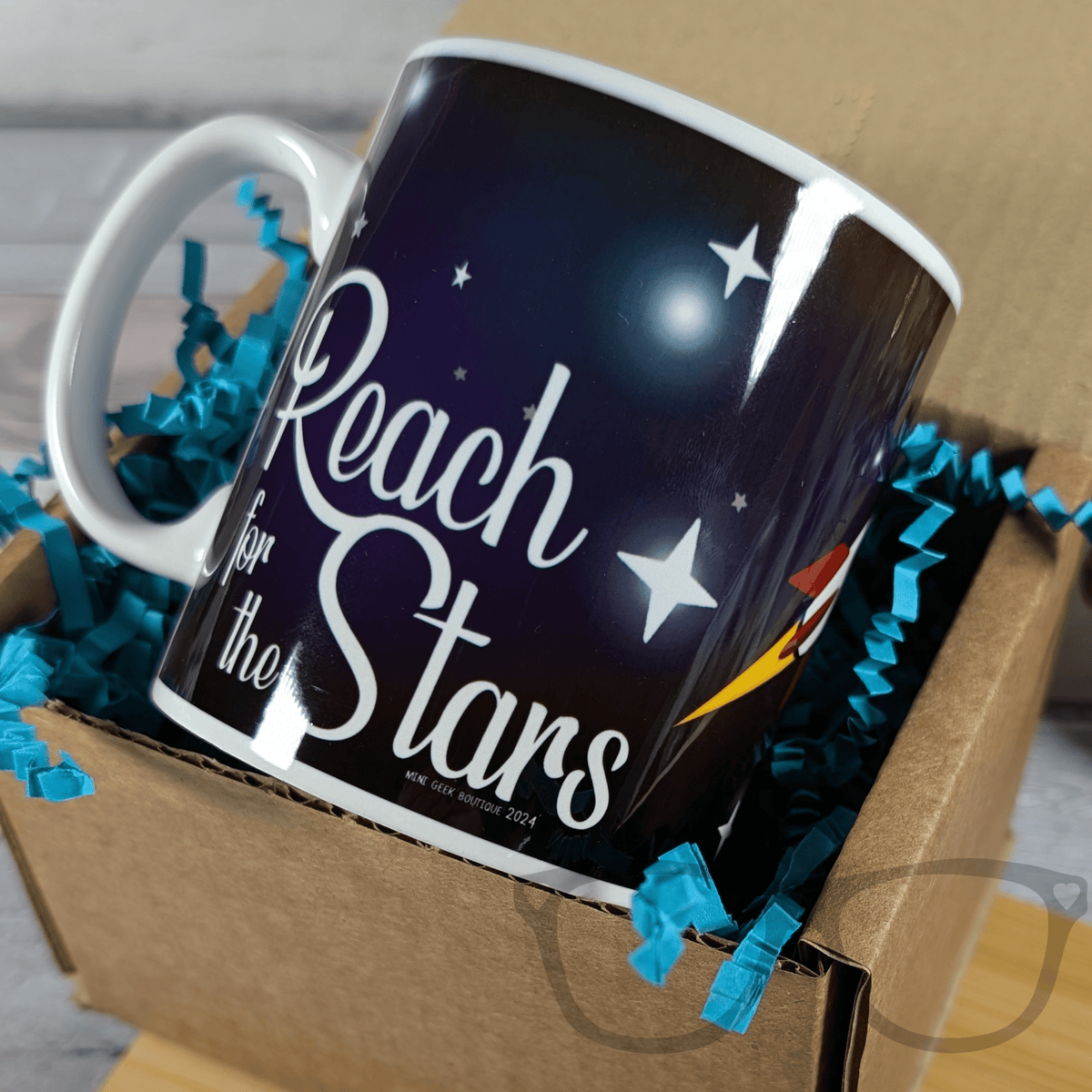 Mug with 'Reach for the Stars' text in a box with blue ribbons