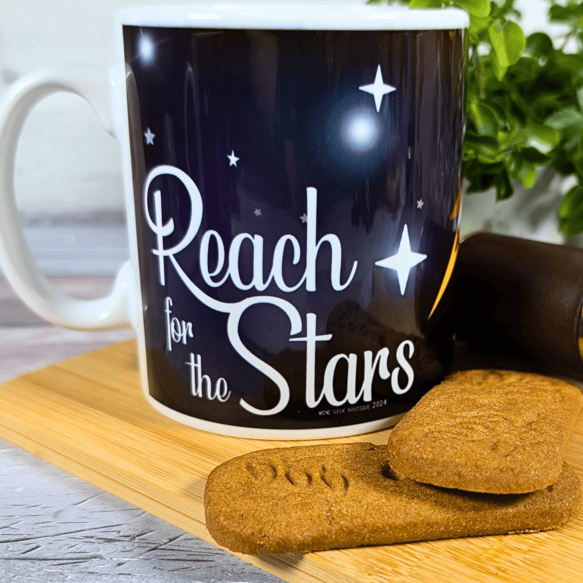 Mug with 'Reach for the Stars' text on a wooden board with cookies