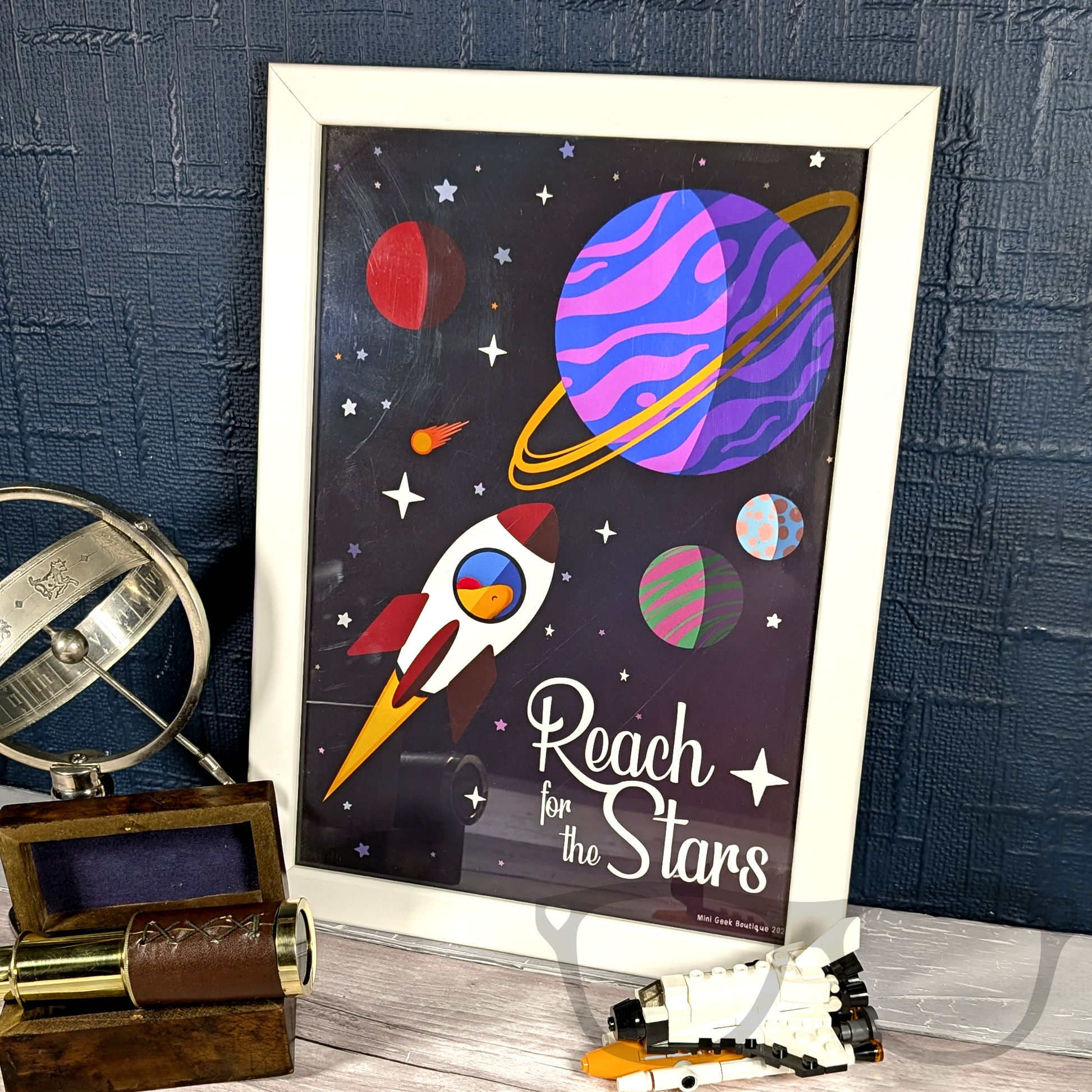 Reach for the stars art print, ideal for decorating any room or study, image shows a framed digital illustration of Derek in a rocket flying through space with the text "Reach for the stars"