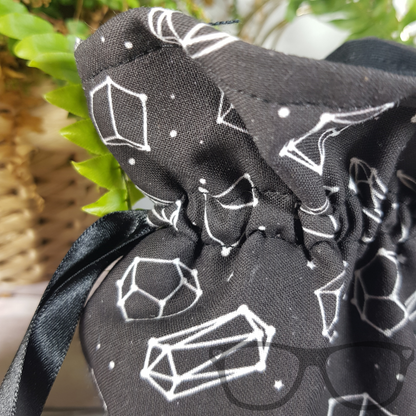 Close up detail showing the black fabric and pattern of the dice bag
