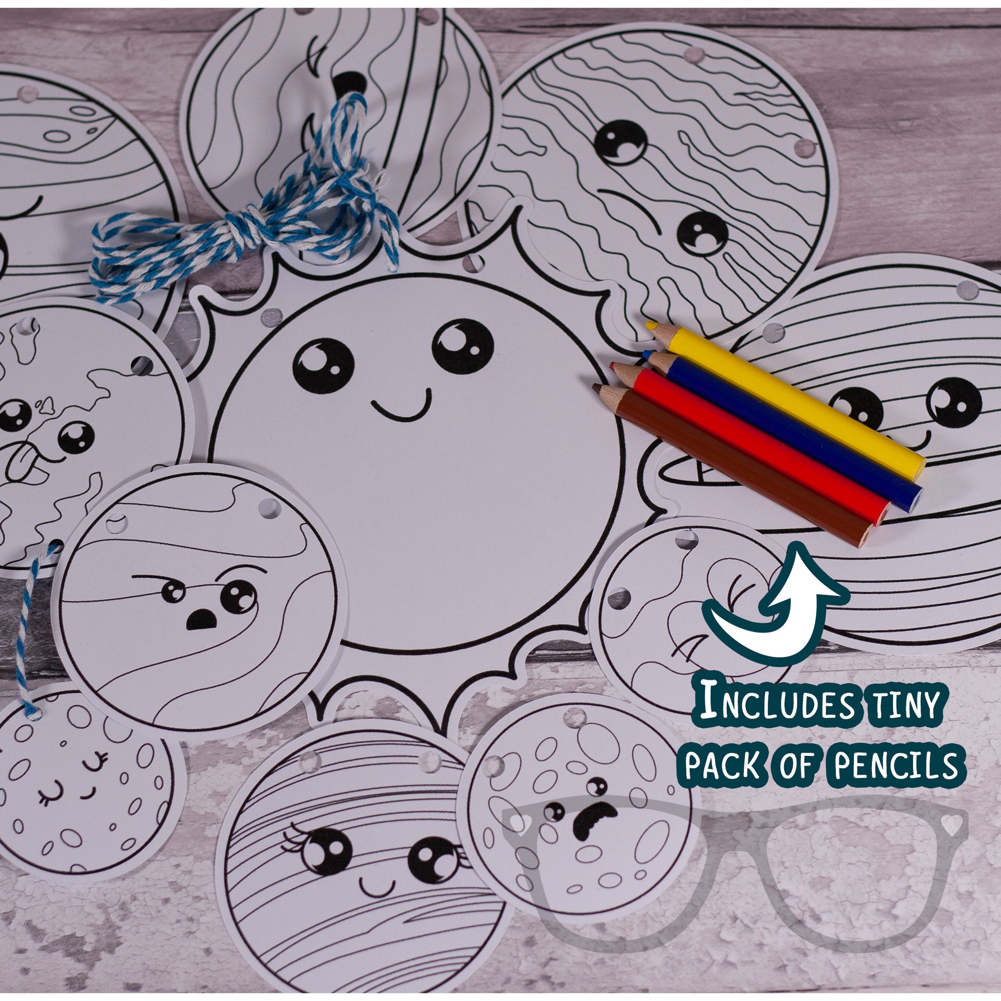 Colour-in solar system bunting with planets, string, and pencils laid out, ready to be coloured and hung up once completed.