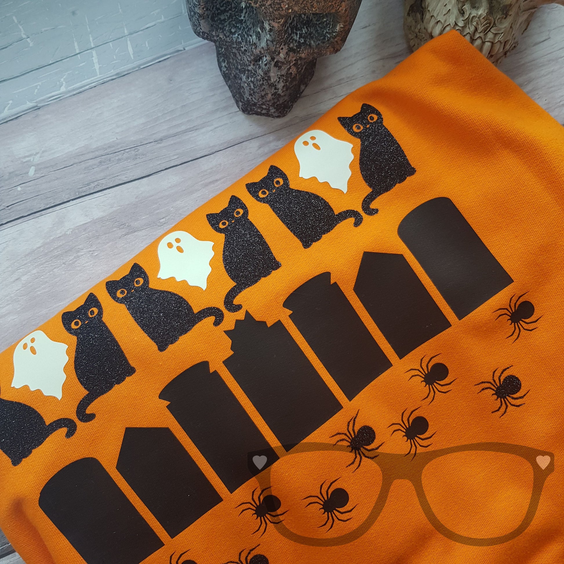 Halloween Sweater showing details of the black glitter cats and glow in the dark ghosts