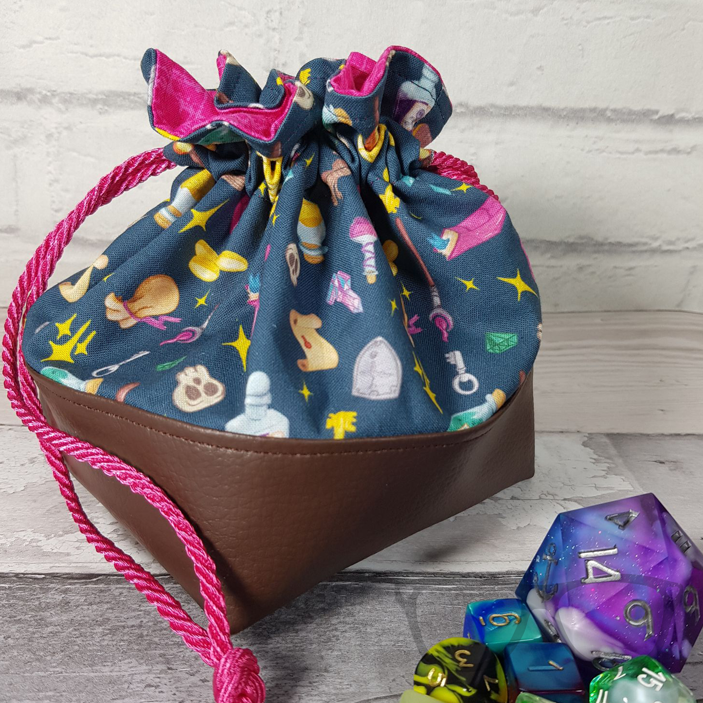 Teal and brown fabric dice bag with pink lining and cord
