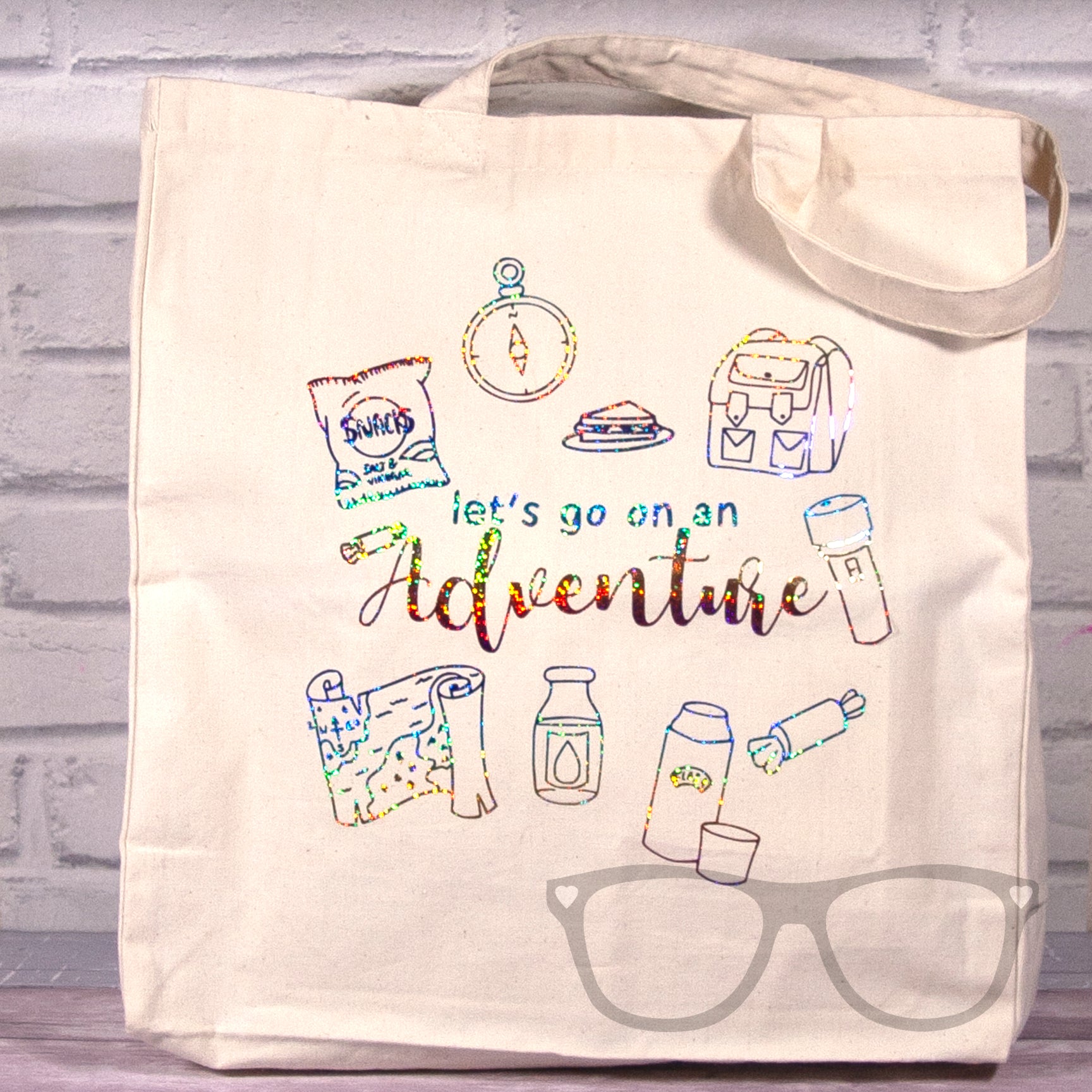 Limited Edition Tote bag with rainbow foil design, the text reads "Let's go on an adventure and features things you would take on an adventure