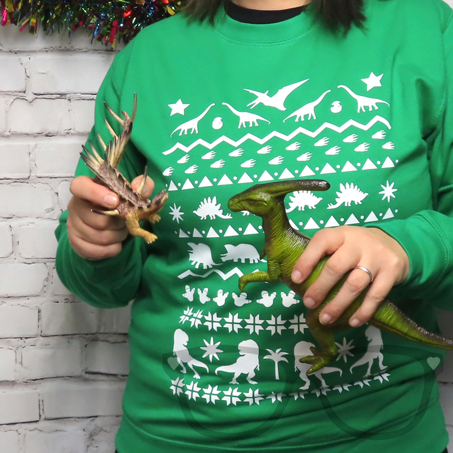 Green sweater with white dinosaur design ideal for the festive and christmas season