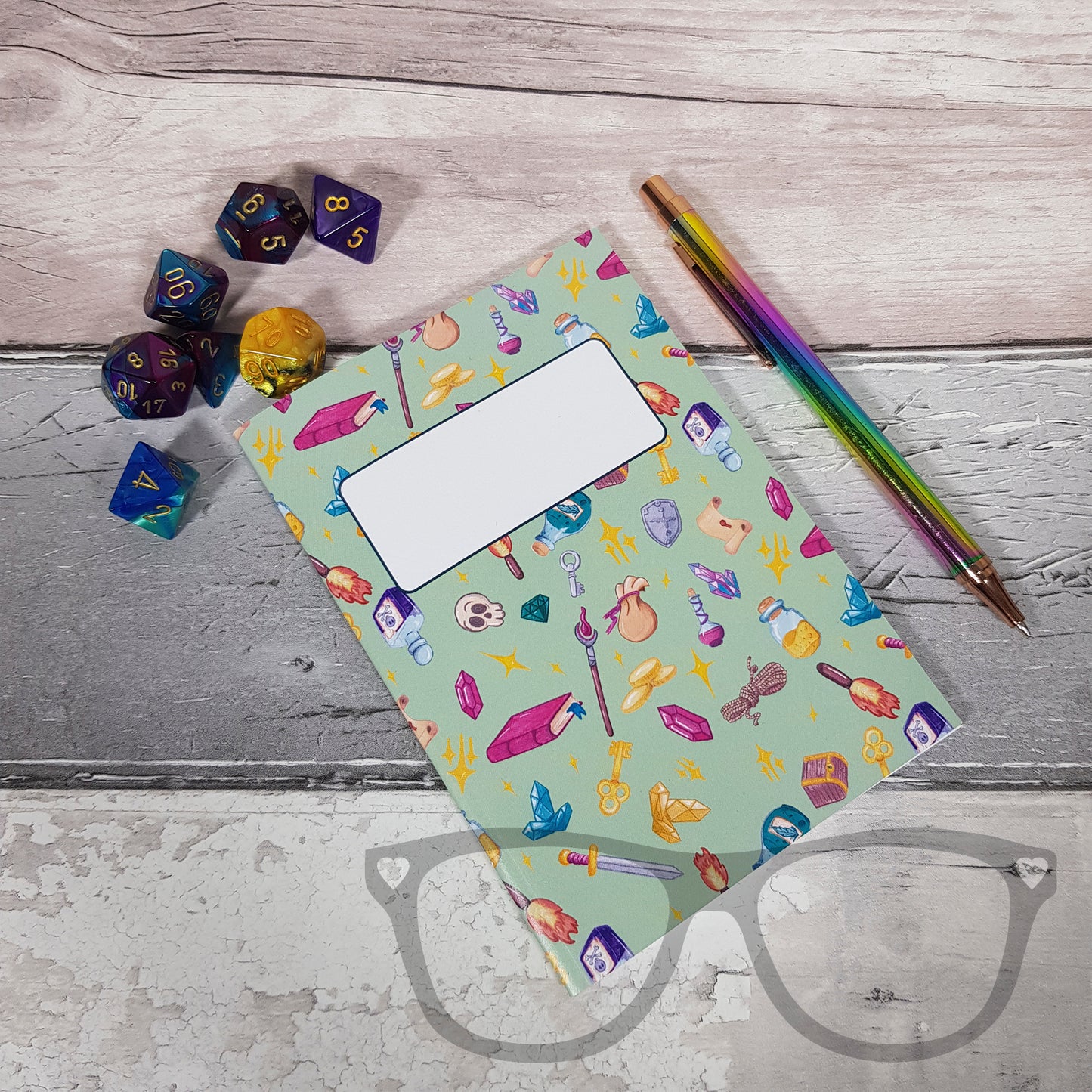 A closed A6 green notebook showing various items you would have on a DnD fantasy roleplaying game