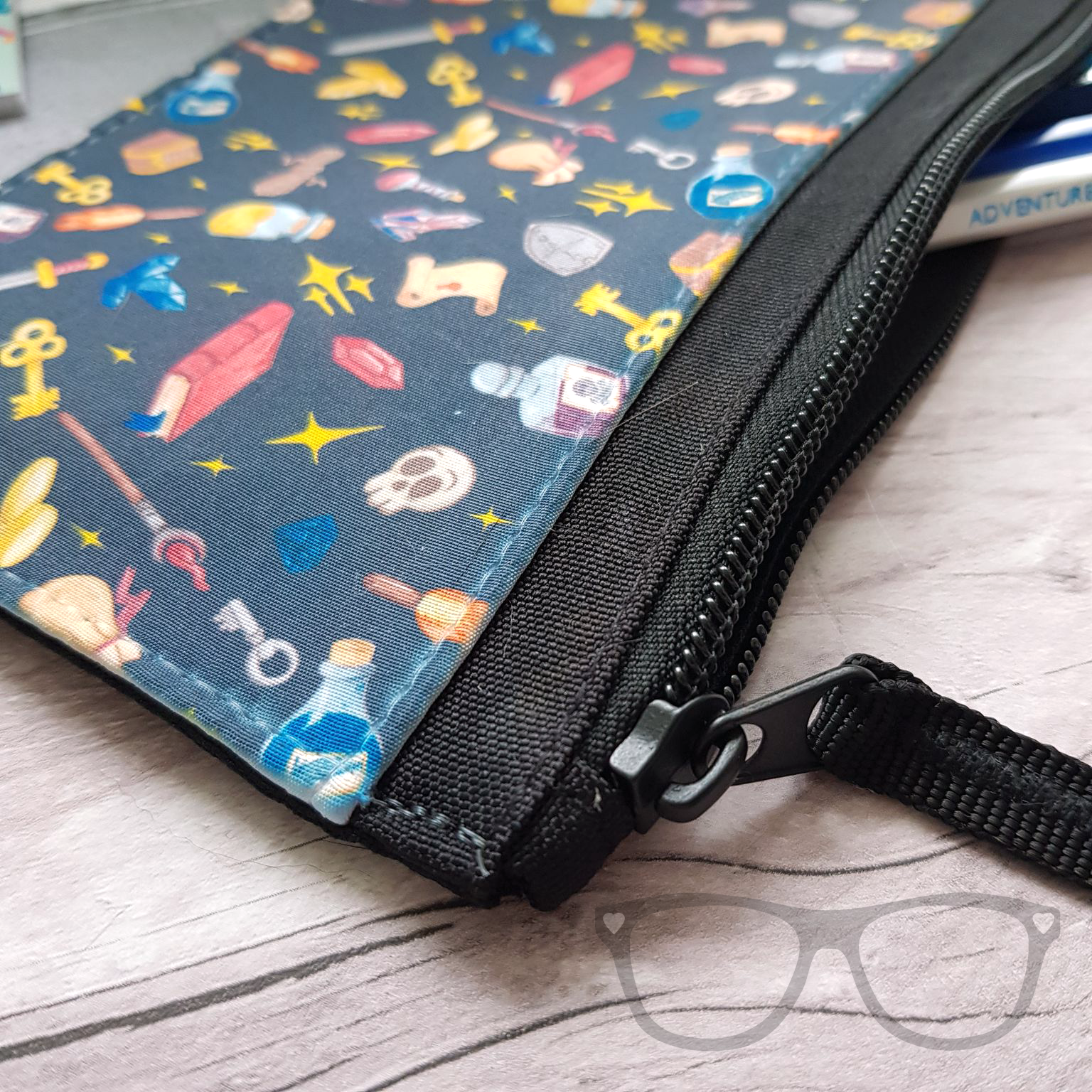 Close up detail of the fantasy genre pencil case showing the black metal zip and the pattern of the pencil case
