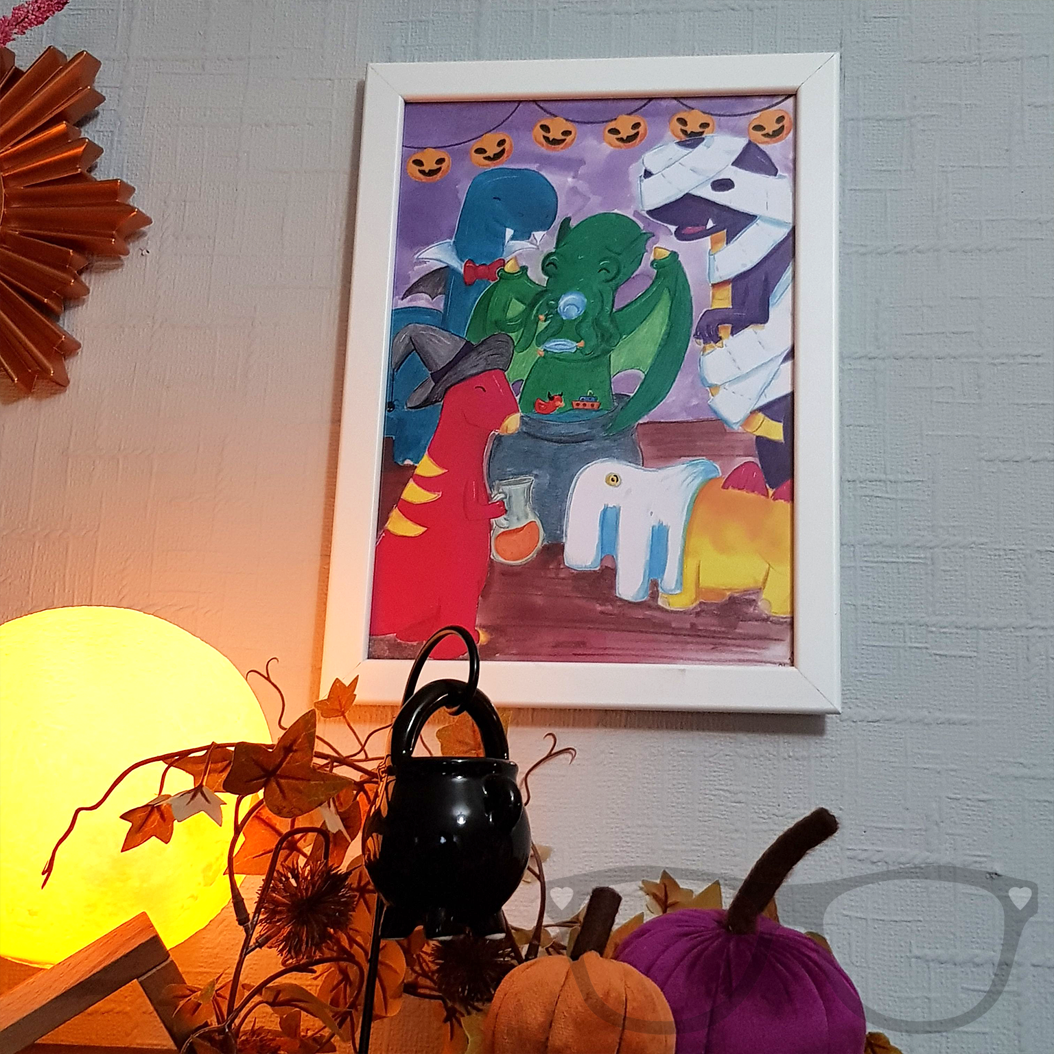 Dinosaur Halloween A4 Art print in a frame on the wall. A digital art print ideal for displaying in offices, nurseries or bedrooms.