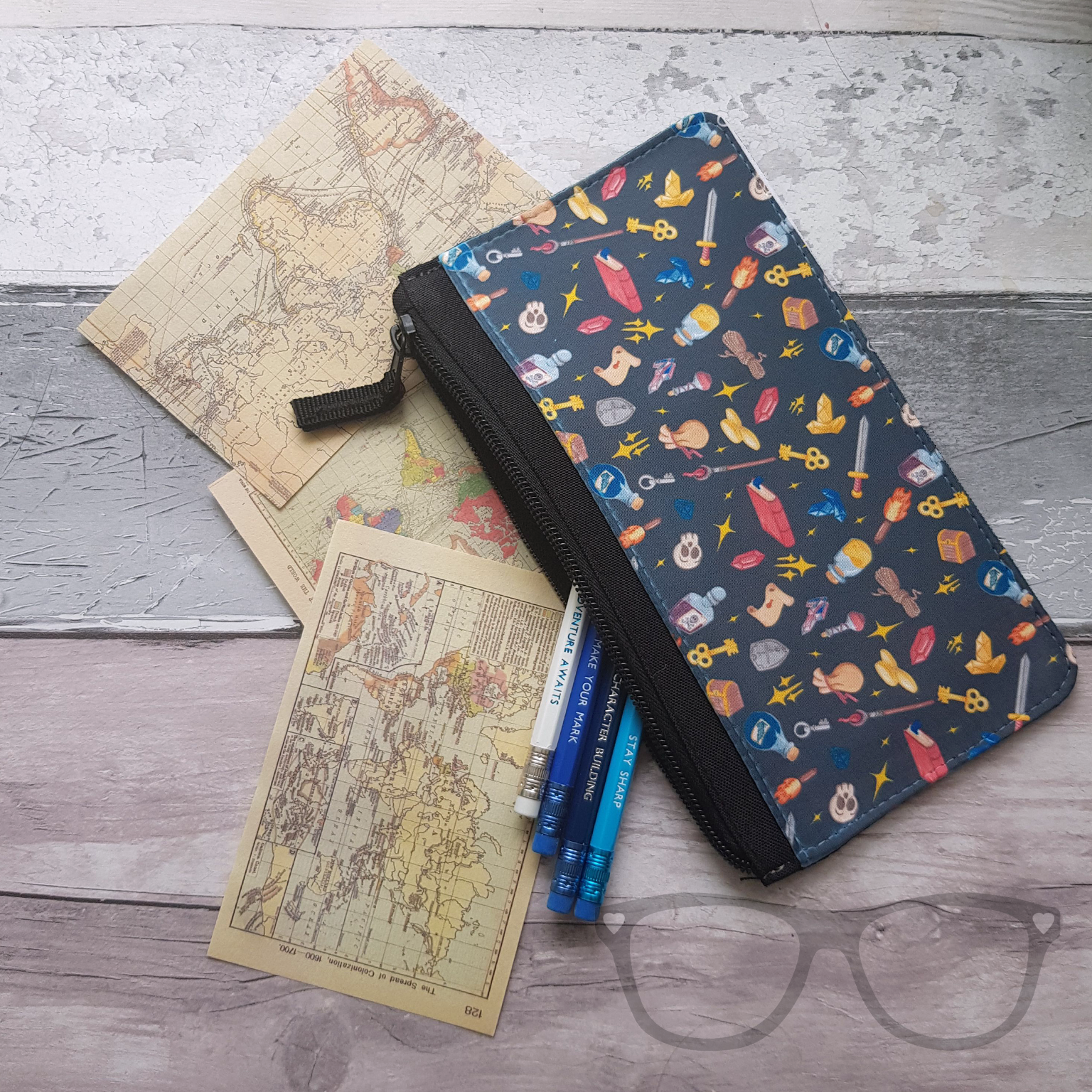 Fantasy genre pencil case shown with small maps and pencils