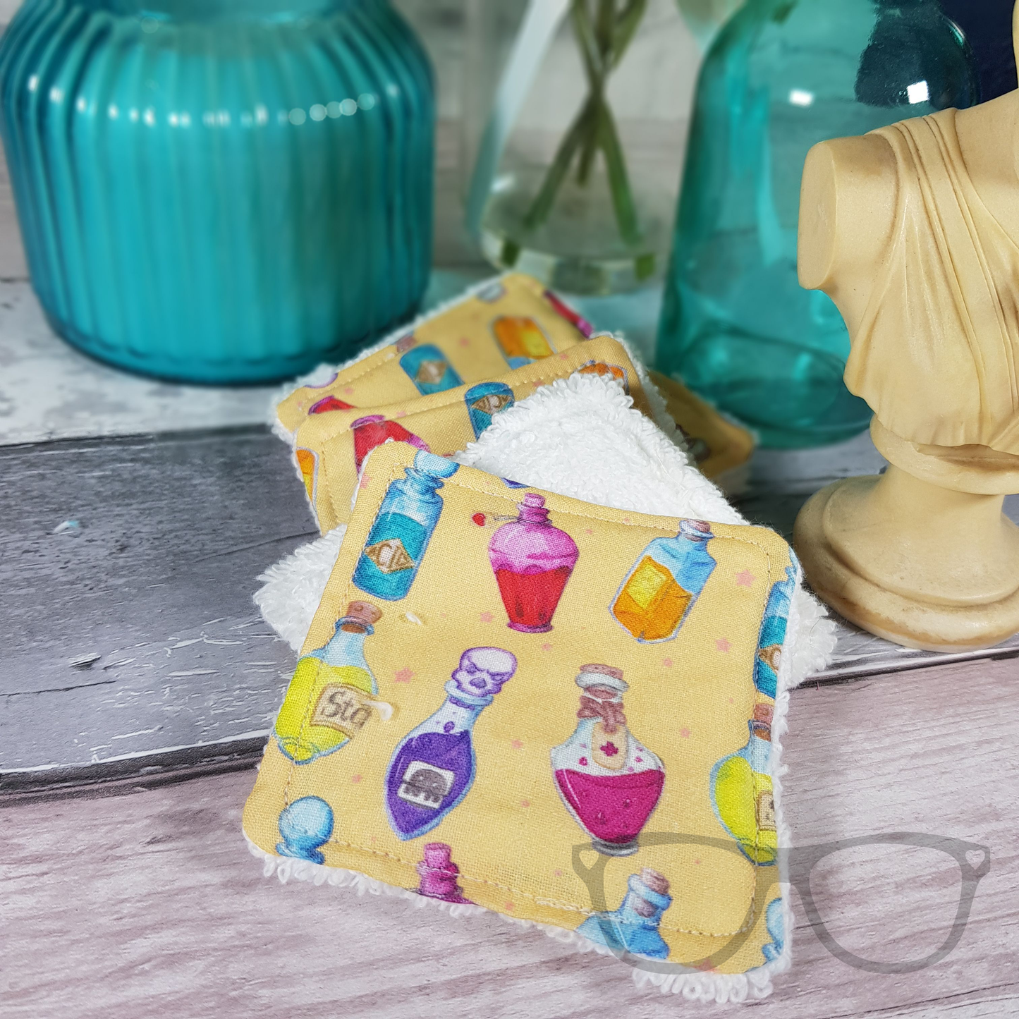 Reusable face wipes, ideal for cleansing your face or removing make up. Pattern shows potion bottles on a light yellow background.
