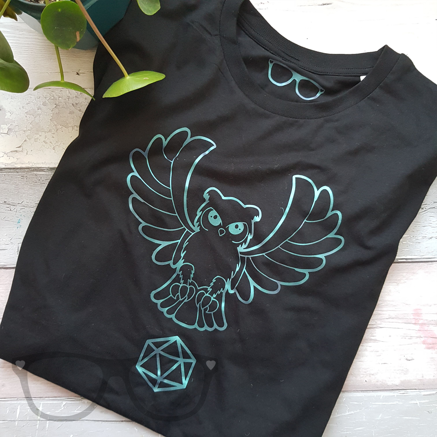 Folded black organic t-shirt with owl design on front